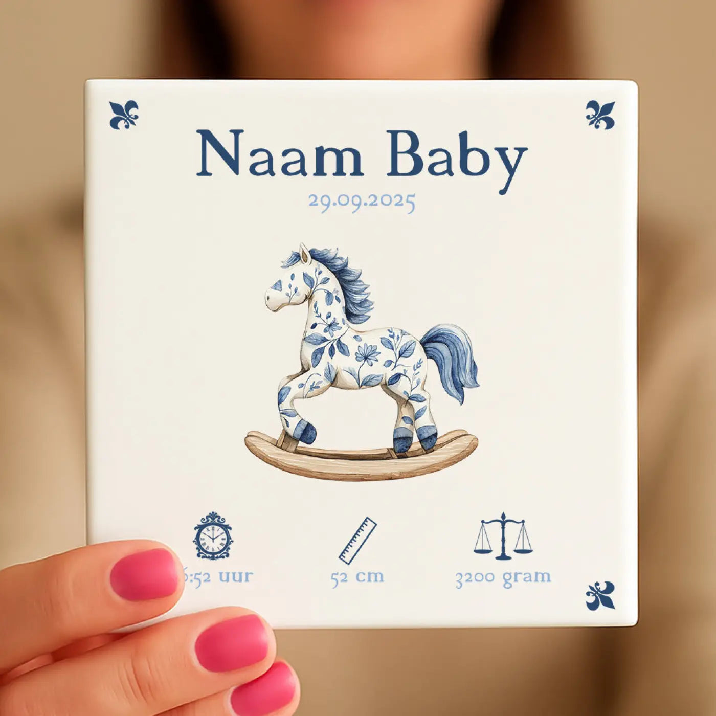 Een wit keramisch geboortekaartje met een blauw bloemrijk hobbelpaard voor babyseizoen
