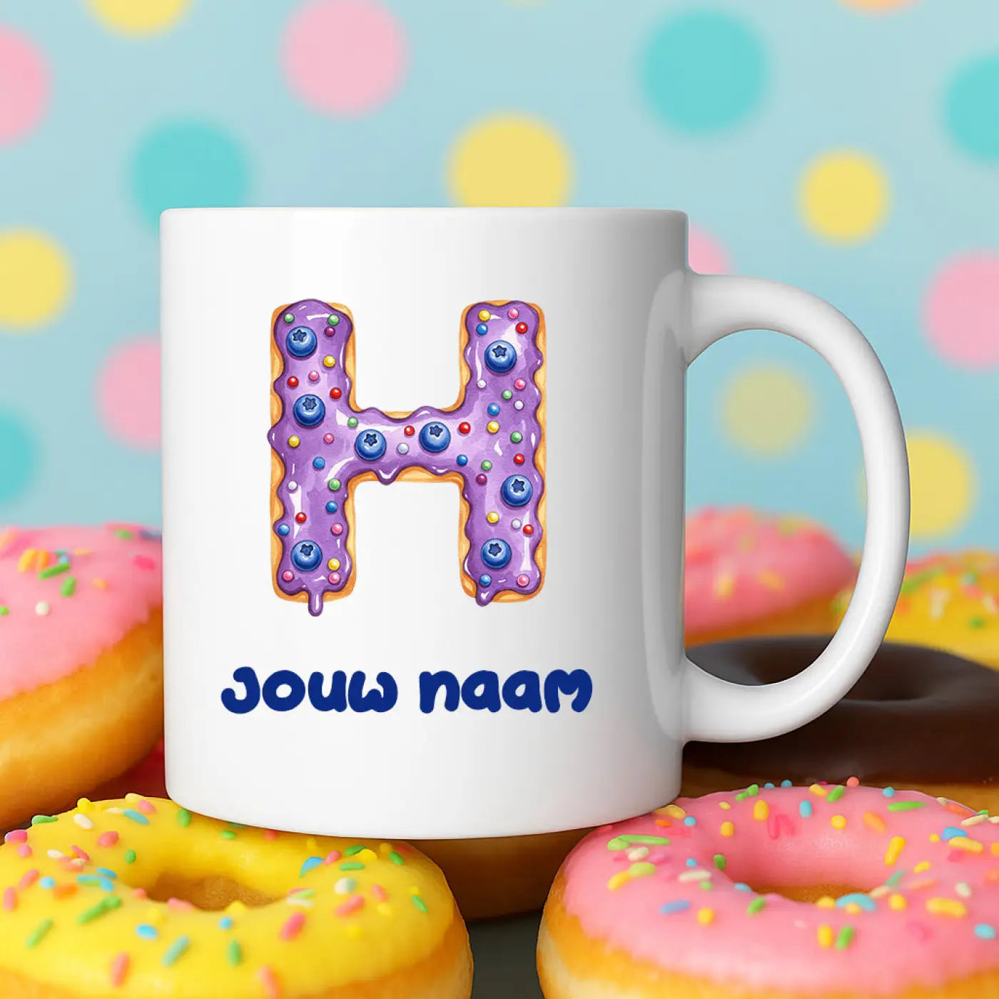 Witte keramische donut mok h met paarse bevroren h versierd met blauwe bessen en regenboog sprinkels en blauwe tekst jouw naam