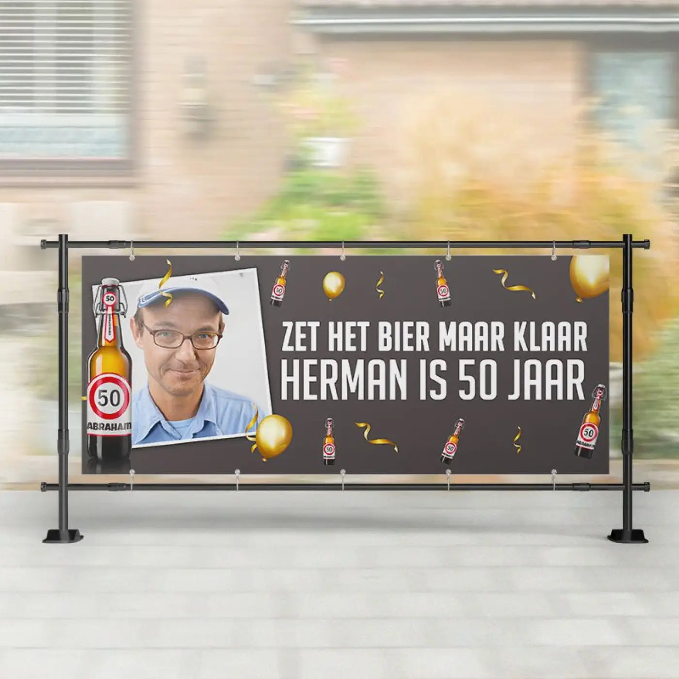 Zwart spandoek abraham met witte tekst, gouden confetti, foto van man met bril en blauwe pet, illustraties van bierflesjes