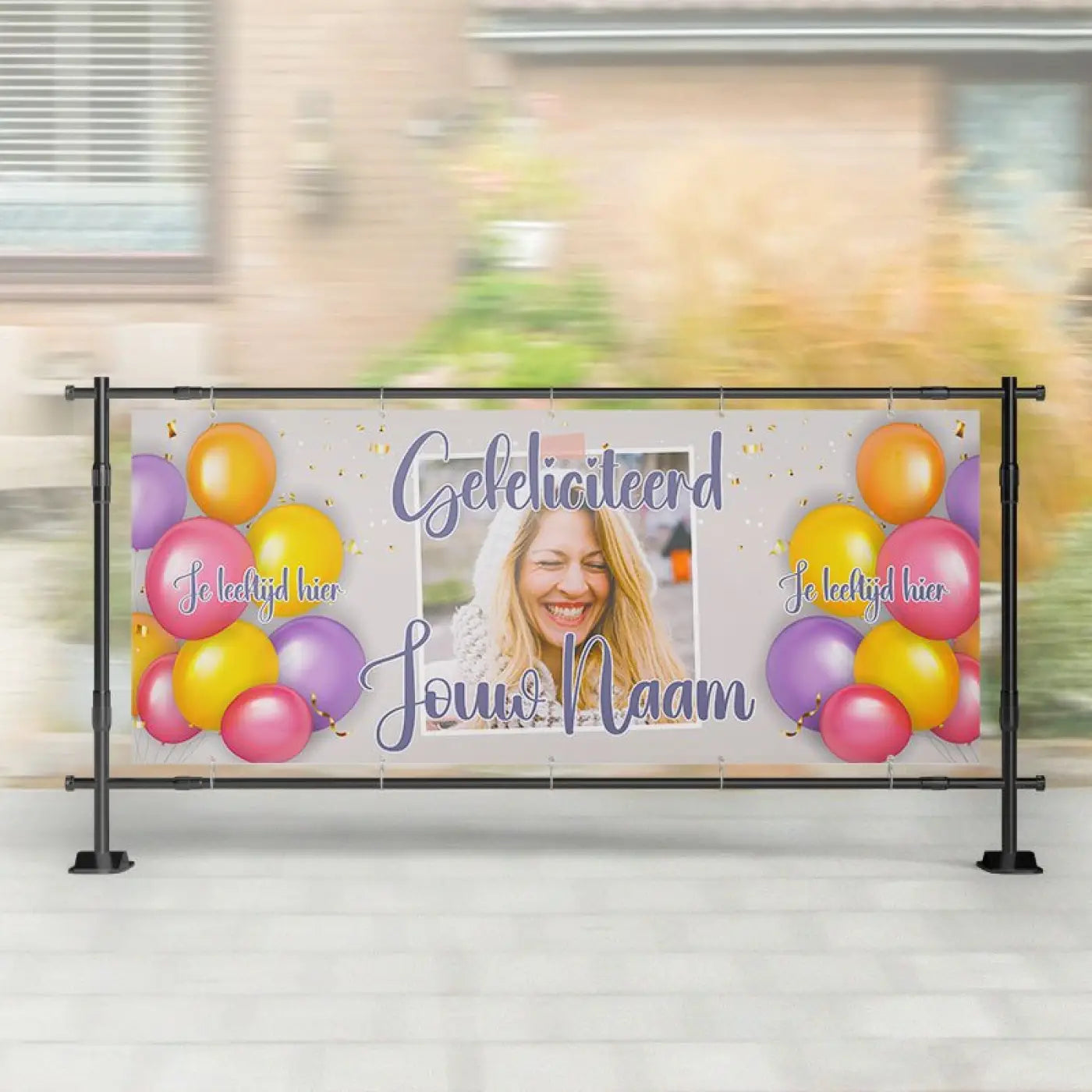 Een vrolijk spandoek verjaardag met naam en leeftijd met foto van lachende vrouw en roze, gele en paarse ballonnen